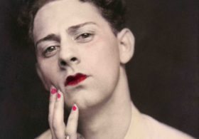 Man in makeup wearing ring. Photograph from a photo booth, with highlights of color. United States, circa 1920. © Sebastian Lifshitz Collection