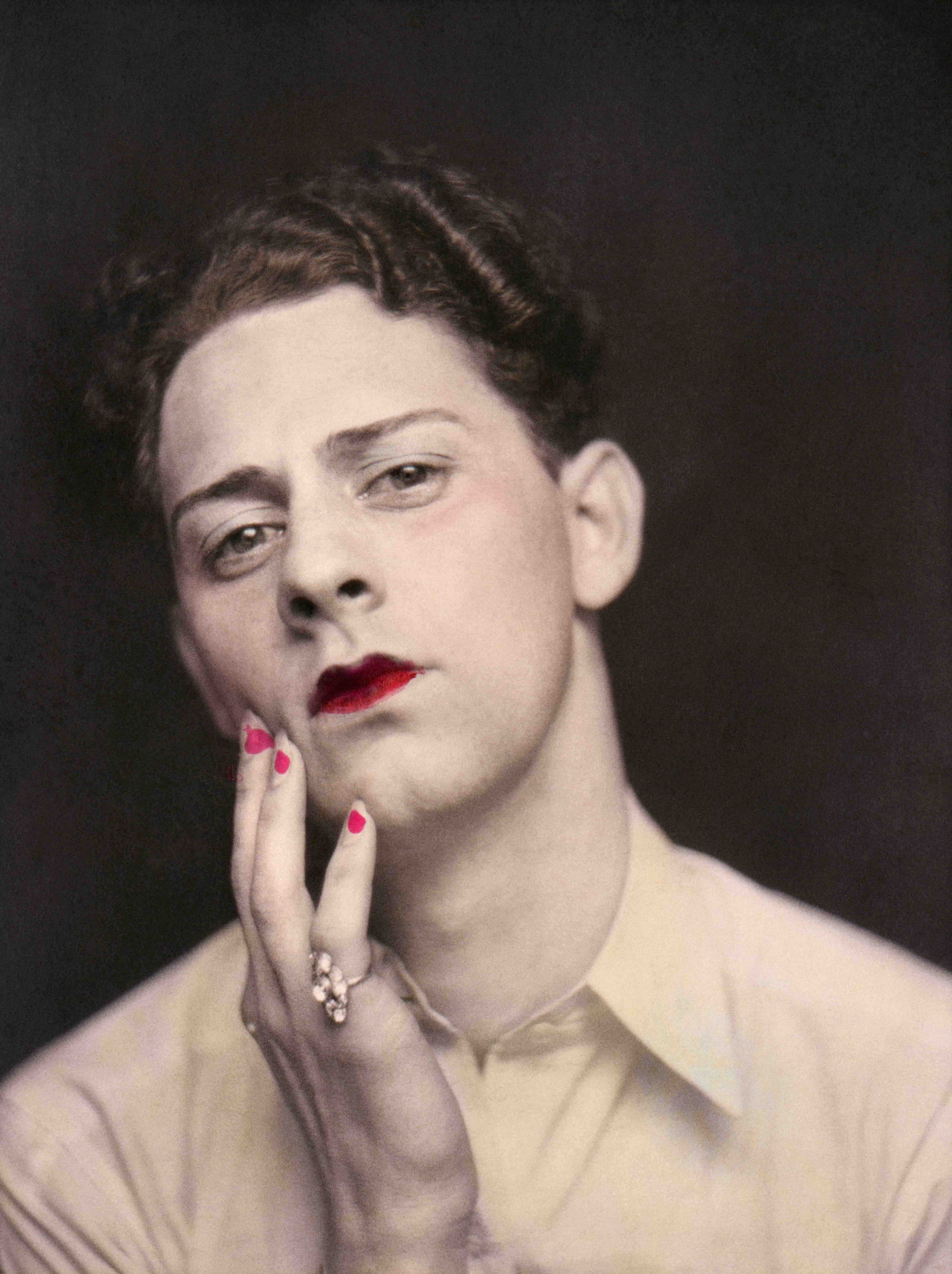Man in makeup wearing ring. Photograph from a photo booth, with highlights of color. United States, circa 1920. Â© Sebastian Lifshitz Collection