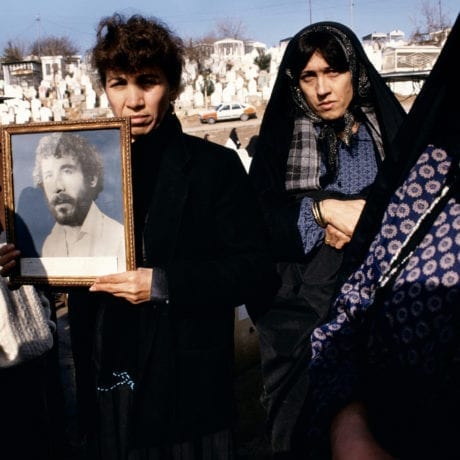 Susan Meiselas Photographs of 20-year-old Kamaran Abdullah Saber are held by his family at Saiwan Hill cemetery. He was killed in July 1991 during a student demonstration against Saddam Hussein, Kurdistan, Northern Iraq, 1991. © Susan Meiselas