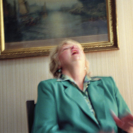 Gretchen Clark laughs as her deceased brother Chapman interrupts a reading to tell her a joke, Lily Dale, New York, 2001. From Séance by Shannon Taggart