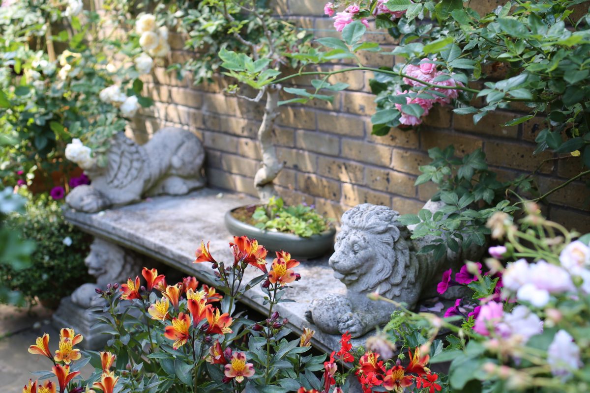 Two stone lions flank a bench adjacent to the Bonsai garden