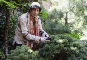 Raqib Shaw tending to his plants in his Peckham garden, located on the site of a former sausage factory