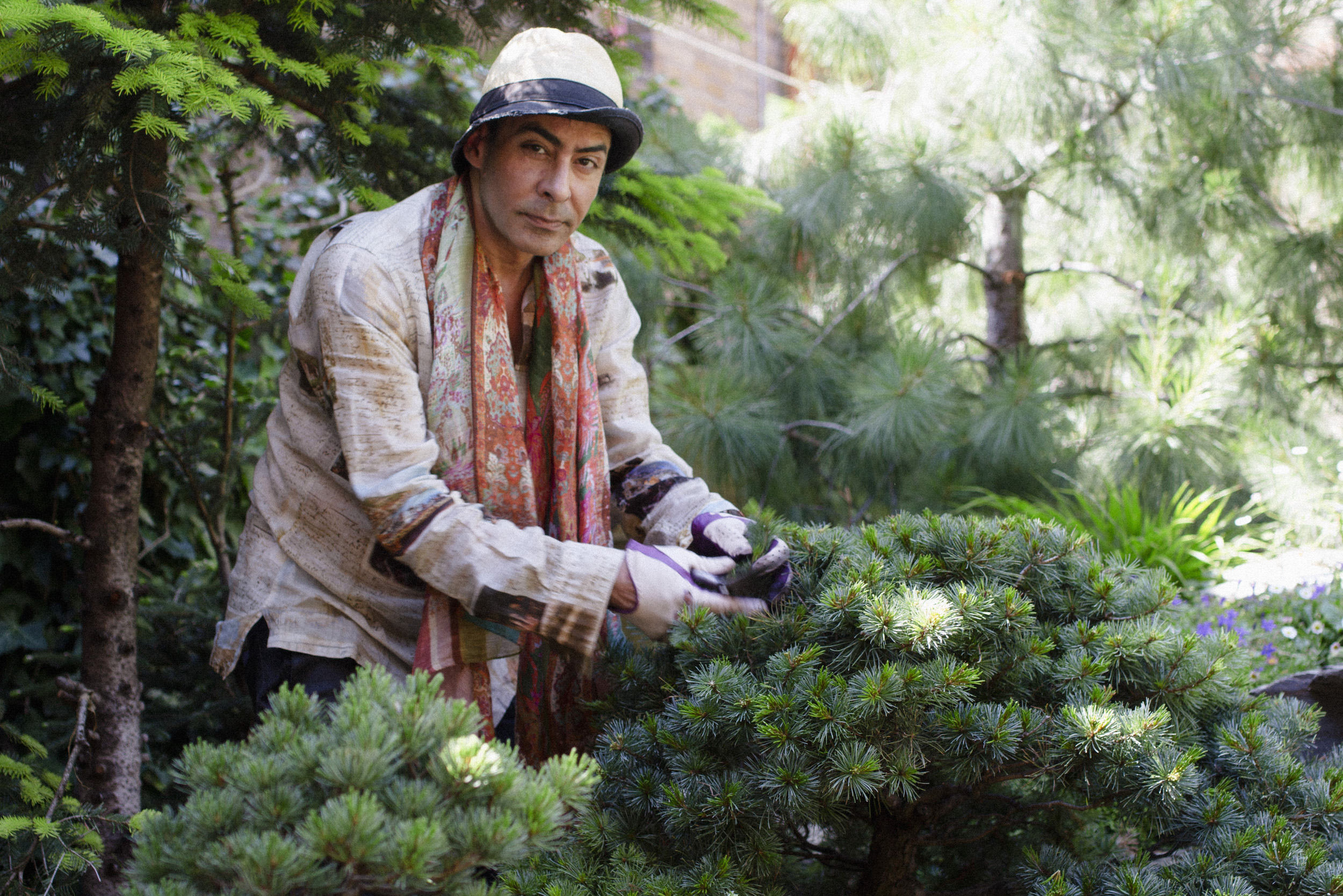 Raqib Shaw tending to his plants in his Peckham garden, located on the site of a former sausage factory